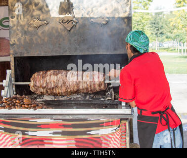 Chef vêtu de rouge turc coupe Cag Kebab à afficher Banque D'Images