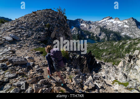 Backpacker femelle des randonnées le long de la montagne rocheuse vers rirge Banque D'Images