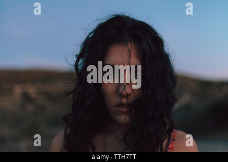 Jeune brunette femme marche sur le terrain dans le coucher du soleil