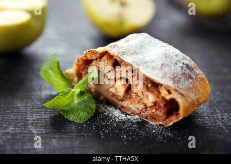 Tranche de gâteau aux pommes, noix et raisins sur table en bois foncé Banque D'Images