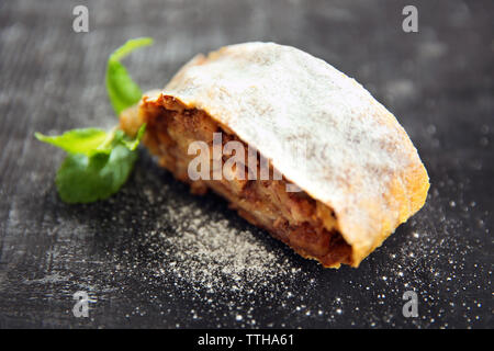 Tranche de gâteau aux pommes, noix et raisins sur table en bois foncé Banque D'Images