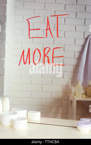 Manger plus de texte écrit sur un miroir dans la salle de bains Banque D'Images