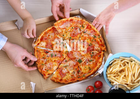 Happy Family eating pizza sur la table en bois Banque D'Images