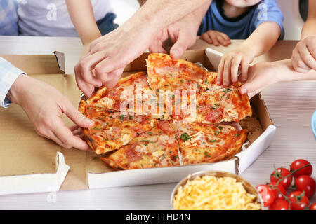 Happy Family eating pizza sur la table en bois Banque D'Images