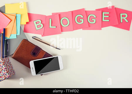 Blogger mot sur une table avec téléphone et portefeuille. Banque D'Images