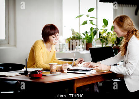 Femme photo editors discuter à 24 dans creative office Banque D'Images