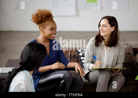 Collègues de sexe féminin ayant discussion dans creative office Banque D'Images