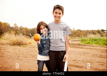 Portrait of happy frères et sœurs sur terrain contre ciel clair Banque D'Images