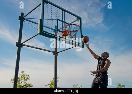 Low angle view of sportsman tremper dans le cercle : balle-against sky Banque D'Images