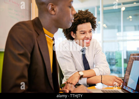 Happy businessman discussing over laptop in meeting Banque D'Images