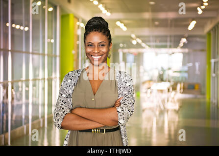 Portrait of confident businesswoman with arms crossed standing in office Banque D'Images