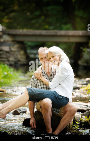 Portrait of senior woman sitting on man's lap en stream Banque D'Images