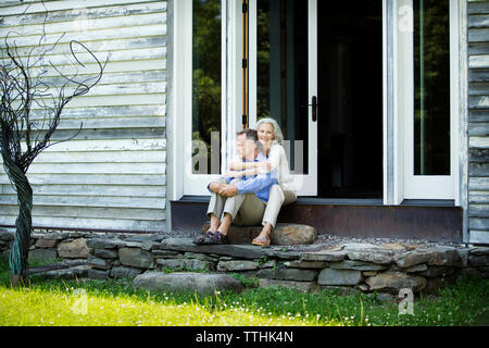 Senior woman embracing man alors qu'il était assis à l'extérieur chambre Banque D'Images