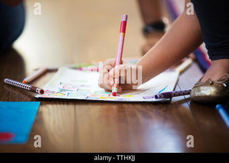 Portrait of Girl dessin sur le papier sur le plancher Banque D'Images