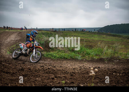 Biker riding on dirt road against sky Banque D'Images