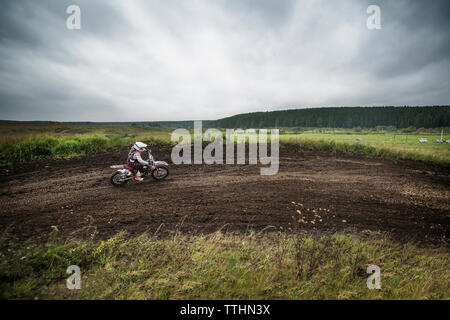 Circonscription de motards les motos sur field against cloudy sky Banque D'Images