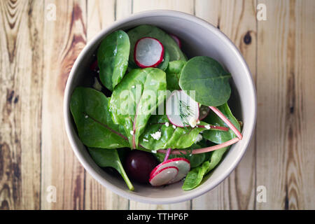 Vue de dessus les épinards et salade de radis aux cerises dans un bol sur la table Banque D'Images