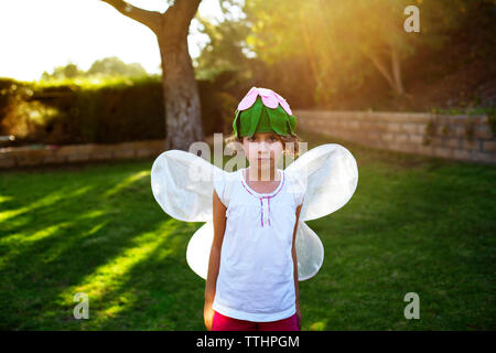 Portrait of Girl in fairy costume standing on grassy field Banque D'Images