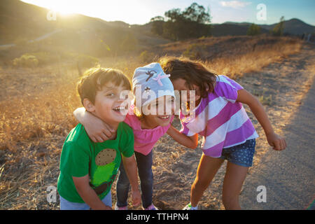 Portrait of boy with sister bénéficiant sur route par domaine Banque D'Images