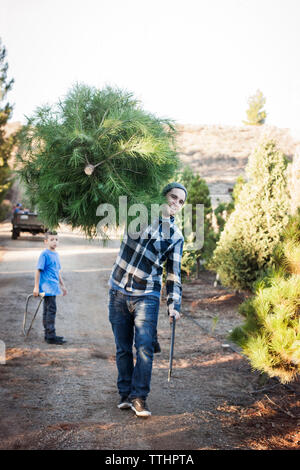 Happy father carrying plante tout en marchant sur la route Banque D'Images