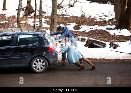 Couple poussant sur la voiture Banque D'Images