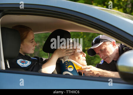 Les ambulanciers mettant neck brace sur patient dans... Banque D'Images