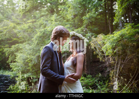 Smiling couple standing in forest Banque D'Images