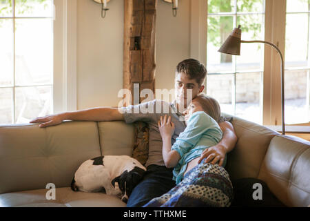 Couple relaxing on sofa in living room à la maison Banque D'Images