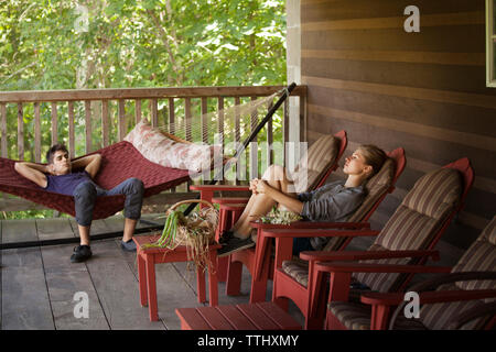 Couple relaxing on porch à l'accueil Banque D'Images