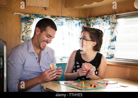 Couple heureux jouer jeu en position assise, dans le camping-car Banque D'Images