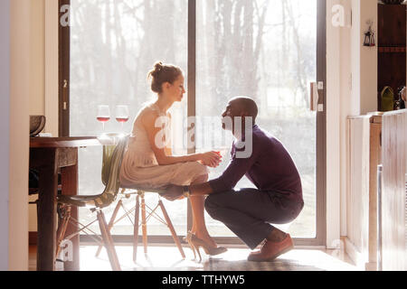 Man woman sitting on chair par fenêtre à la maison Banque D'Images