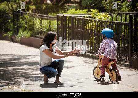 Happy woman looking at boy le vélo sur route Banque D'Images