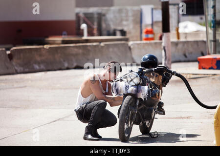 Vue latérale du ravitaillement en carburant de l'homme à la pompe à carburant moto Banque D'Images