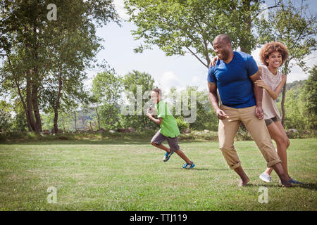 Happy Family playing football on grassy field Banque D'Images