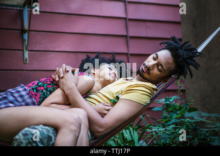 Woman man sleeping on hammock in lawn Banque D'Images