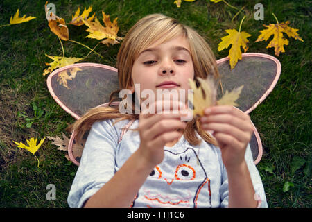 High angle view of girl in fairy costume holding pendant qu'ly8ing sur déposée Banque D'Images