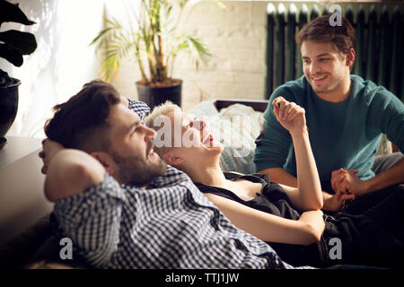 Happy friends on sofa at home Banque D'Images