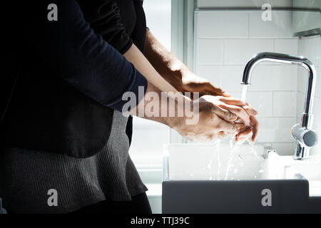 Portrait couple aimant lave-mains dans la salle de bains Banque D'Images