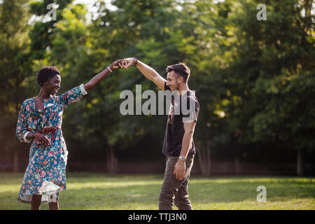 Heureux couple dancing at park Banque D'Images