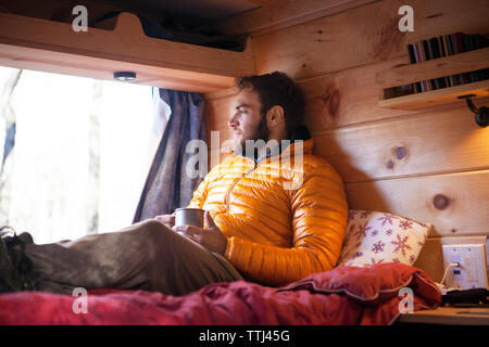 Thoughtful man relaxing in camper van Banque D'Images