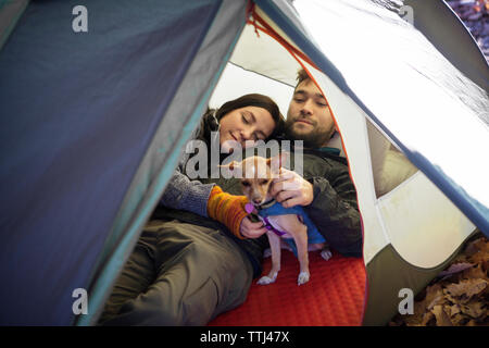 Couple avec chien en relaxant tente Banque D'Images