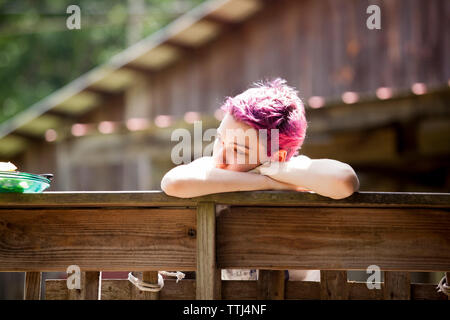 Close-up of woman leaning on balustrade de bois Banque D'Images