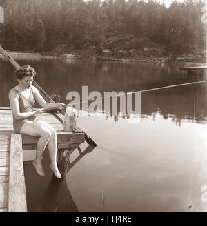 La pêche dans les années 1950. Une jeune femme portant un maillot de bain est la pêche. Kristoffersson ref K51-4 Suède 1945 Banque D'Images