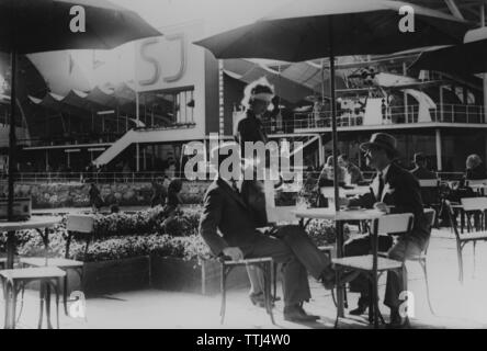 1930 café en plein air. Deux hommes sont servies des boissons à la table par une serveuse au motif de l'exposition de Stockholm de 1930. Banque D'Images