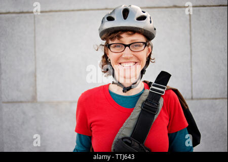 Portrait de femme au casque de vélo contre le bâtiment Banque D'Images