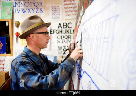 L'homme écrit sur papier en atelier Banque D'Images