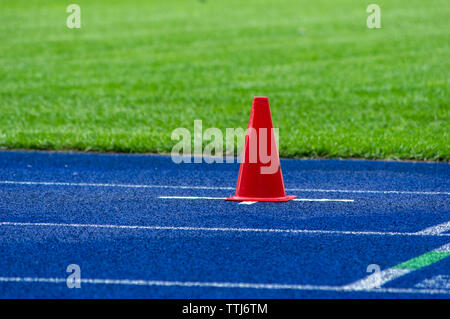 Cône de trafic sur la piste en tartan bleu dans le stade Banque D'Images