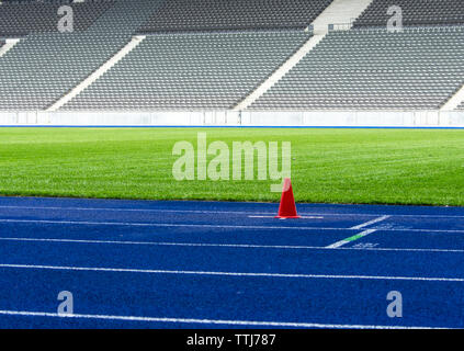 Cône de trafic sur la piste en tartan bleu dans le stade Banque D'Images