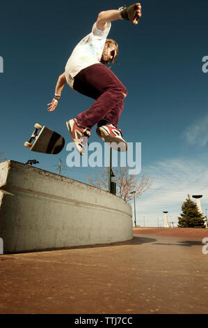 Low angle view of man performing stunt sur mur de retenue Banque D'Images