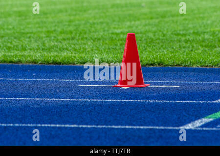 Cône de trafic sur la piste en tartan bleu dans le stade Banque D'Images